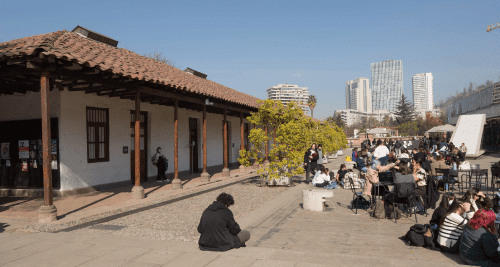 Se observan estudiantes en la explanada del edificio.